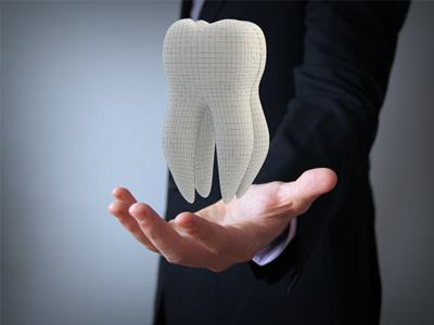 man in suit holding tooth