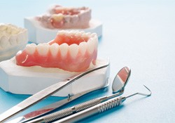 A closeup of a full denture on a blue background
