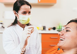 A dentist holding a woman’s extracted tooth 