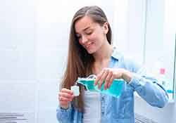 a woman preparing to rinse with mouthwash