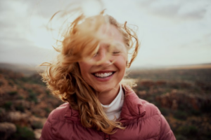 Woman smiling brightly as the wind caresses her hair